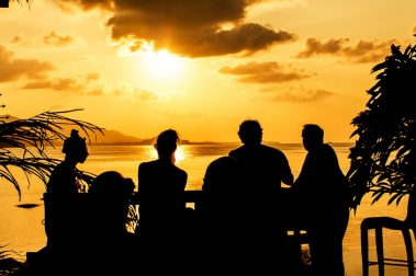 silhouette of a group dining at sunset