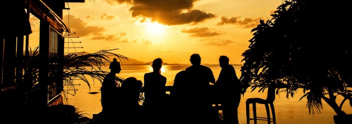 silhouette of a group dining at sunset