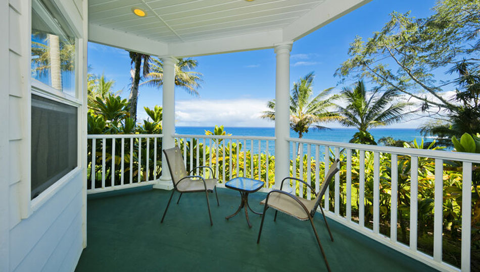 Photo of a porch overlooking the ocean with a table and chairs at the Bliss Island Estate