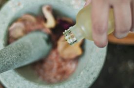 person mixing oil into a hand made remedy at a Big Island Spa