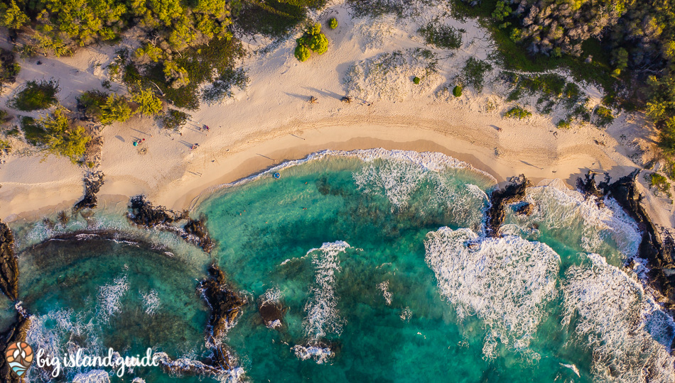 Aerial Photo of white sand crescent and teal water at Makalawena Beach