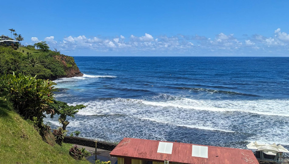 view above Honolii Beach with beach shack and lifeguard station below