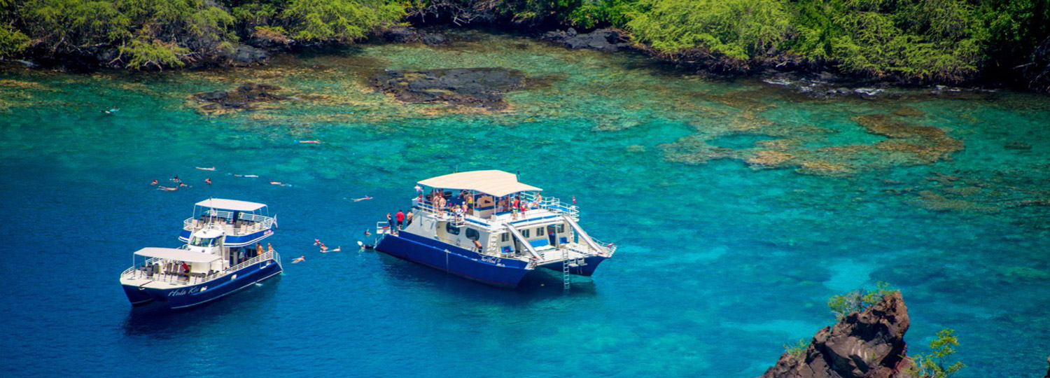 Photo Courtesy of Fair Wind Cruises showing two of their boats in a beautiful bay off Hawaii Island