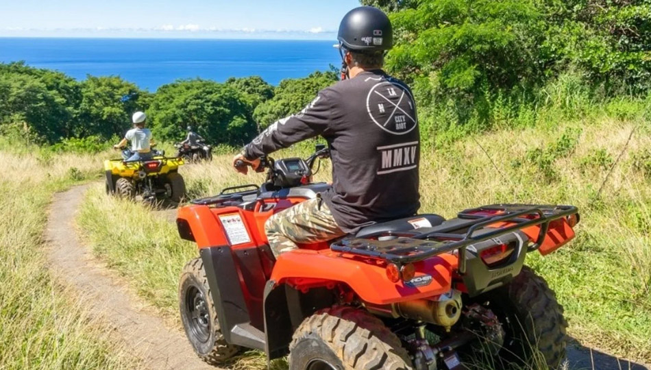 People riding ATVs in Hawaii with an ocean view